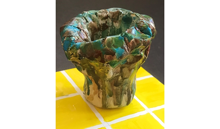 photo of green pot on a table top decorated with yellow squares